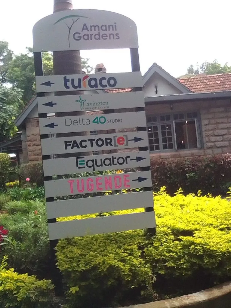 directional wayfinding sign made of metal and alucobond-company logos are displayed on the sign in colour with an arrow to the left or right side