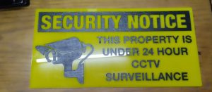 laser engraved security sign on yellow acrylic